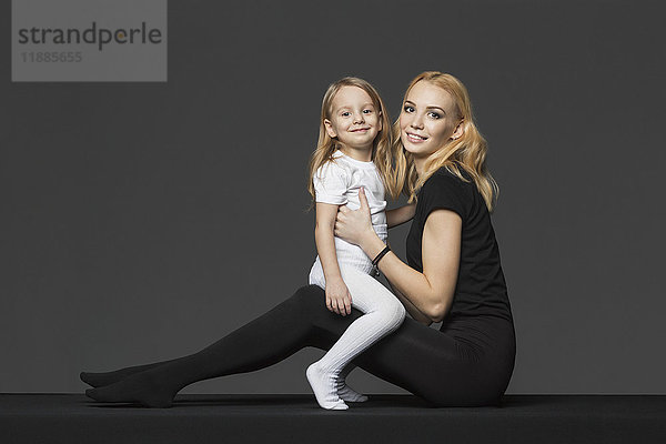 Seitenansicht Porträt von Mutter und Tochter auf grauem Hintergrund