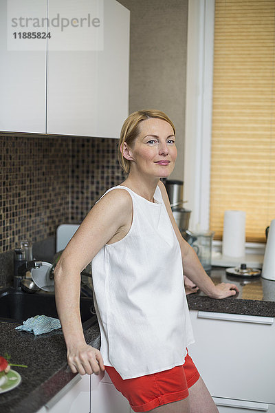 Lächelnde Frau an der Theke in der Küche