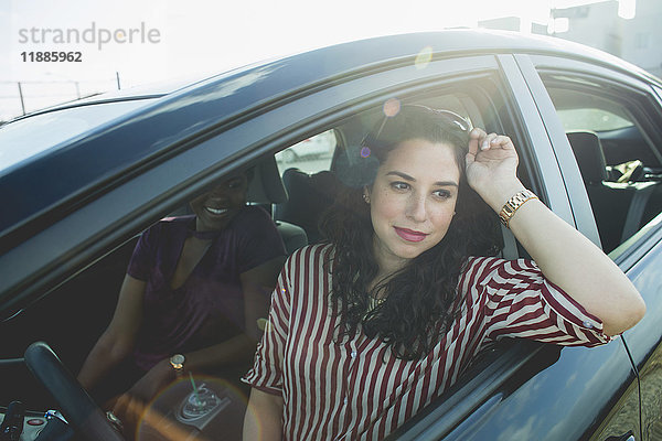 Frauen schauen weg  während sie mit einer jungen Freundin im Auto sitzen.