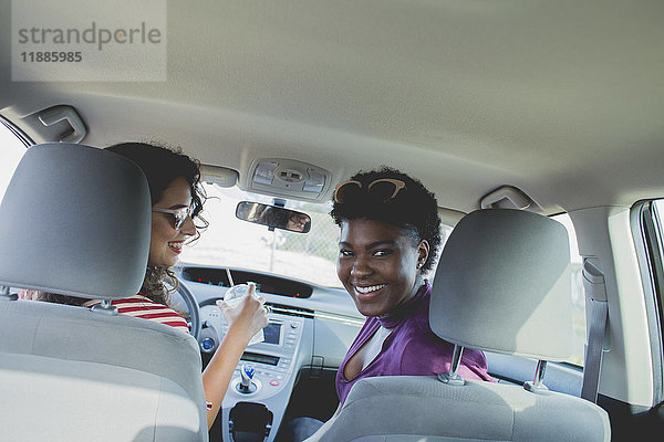 Neigungsaufnahme von glücklichen Freundinnen  die im Auto sitzen.