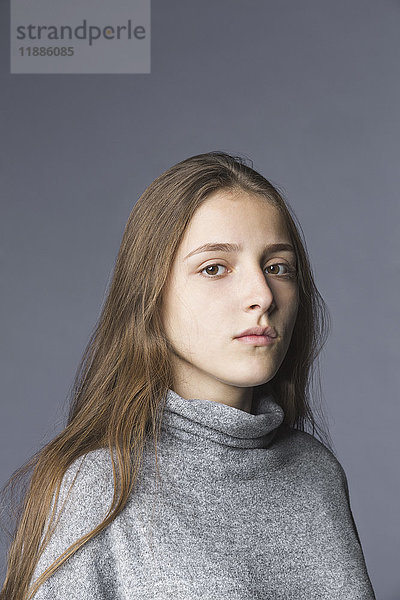 Porträt eines Teenagermädchens vor grauem Hintergrund