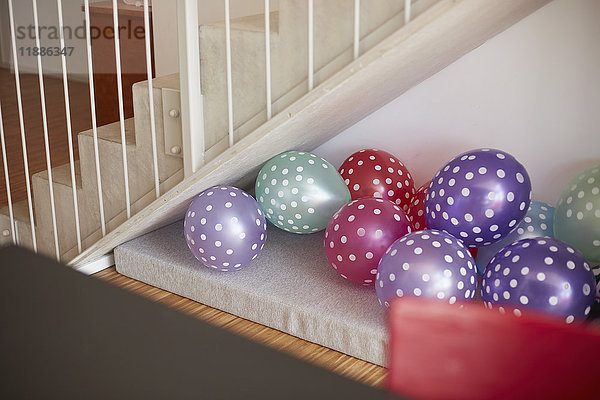 Mehrfarbige Luftballons an der Wand durch Treppenhaus zu Hause