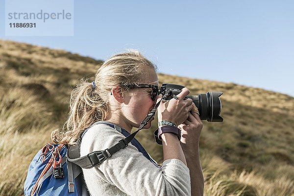 Wanderin beim Fotografieren mit einer Spiegelreflexkamera  Otago  Südinsel  Neuseeland  Ozeanien