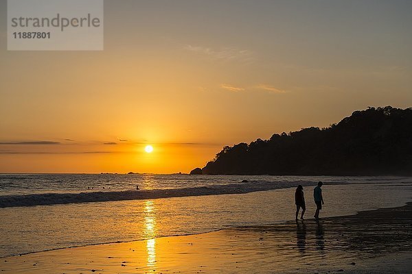 Mann und Frau spazieren am Strand  Sonnenuntergang  Playa Espadilla  Manuel Antonio National Park  Costa Rica  Mittelamerika