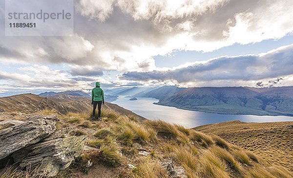 Weibliche Wanderin mit Blick auf See  Lake Hawea und Berglandschaft  Isthmus Peak  Otago  Südinsel  Neuseeland  Ozeanien