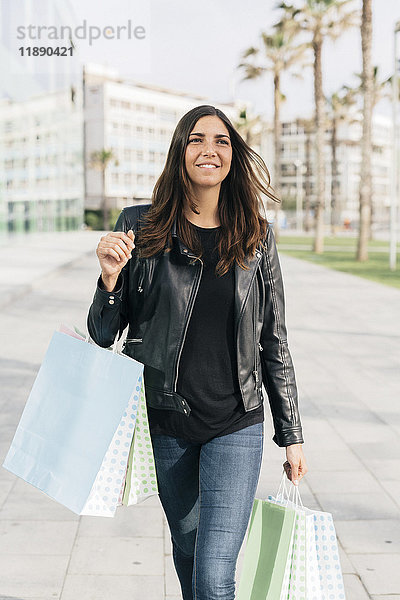 Porträt einer lächelnden Frau mit Einkaufstaschen
