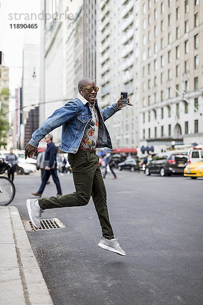 USA  New York City  Manhattan  stilvoller Mann beim Sprung in die Luft