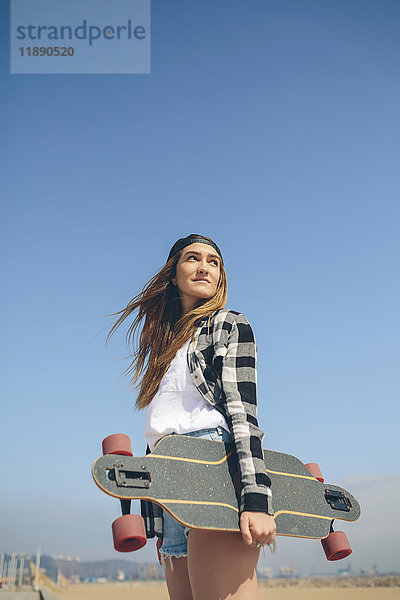 Portrait einer jungen Frau mit Longboard