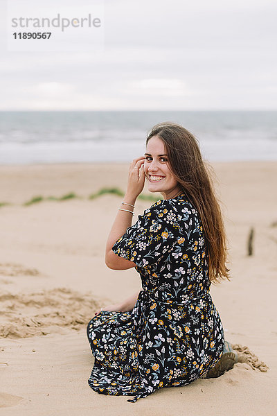 Porträt einer glücklichen jungen Frau am Strand