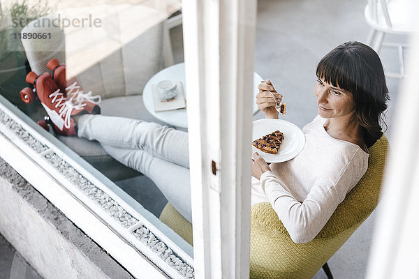 Frau mit Rollschuhen in einem Café sitzend  Kuchen essend