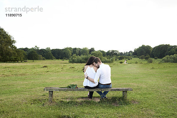 Rückansicht eines Paares auf einer Bank im Park