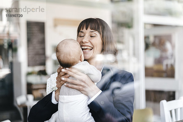 Geschäftsfrau im Café mit ihrem Baby