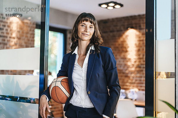 Geschäftsfrau mit Basketball im Amt