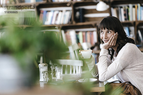 Frau im Café beim Kaffee trinken  Tagträumen