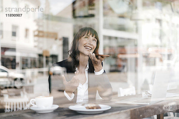 Geschäftsfrau sitzend im Cafe  mit Smartphone