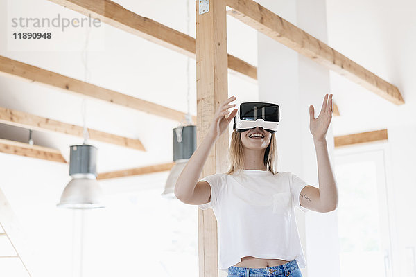 Junge Frau mit VR-Brille  die ihr neues Zuhause entwirft