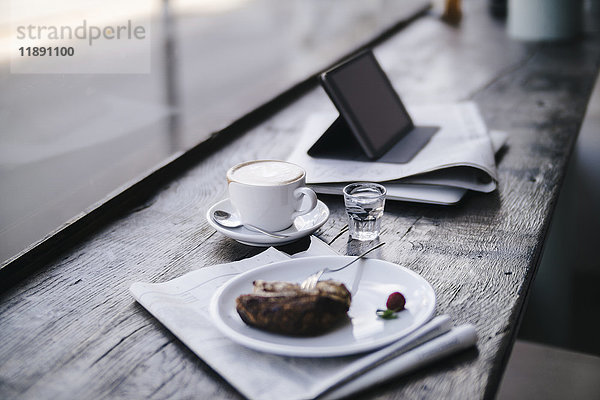 Kuchen  Kaffee und Tablet PC im Regal im Cafe