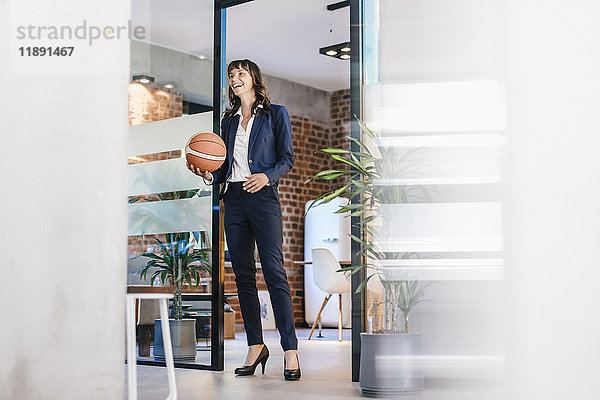Geschäftsfrau mit Basketball im Amt