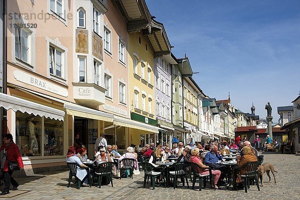 Menschen sitzen in einem Café vor einer Reihe historischer Häuser  Marktstraße  Bad Tolz  Oberbayern  Bayern  Deutschland  Europa