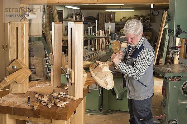 Holzmaskenschnitzer mit Schnitzwerkzeugen an einem Holzblock  Holzmaskenschnitzer  Werkbank  Bad Aussee  Steiermark  Österreich  Europa