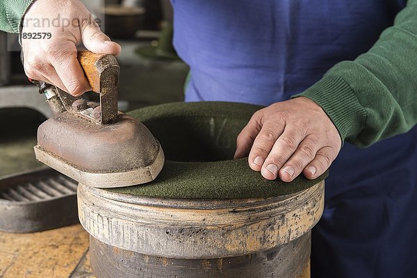 Bügeln eines trockenen Wollfilzhutes über die Kantenform  Hutmacherwerkstatt  Bad Aussee  Steiermark  Österreich  Europa