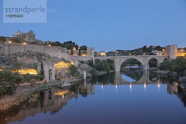 Die Kirche San Juan de los Reyes und die Brücke Puente de San Martin spiegeln sich im Fluss Tajo  Toledo  Kastilien-La Mancha  Spanien  Europa