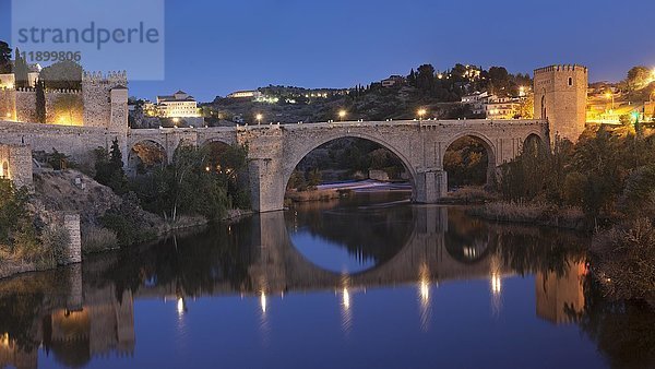 Die Brücke Puente de San Martin spiegelt sich im Fluss Tajo  Toledo  Kastilien-La Mancha  Spanien  Europa