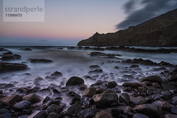 Strand Playa de Caleta mit Felsen und Steinen bei Sonnenuntergang  im Hintergrund Teneriffa  Playa de Caleta  La Gomera  Kanarische Inseln  Spanien  Europa
