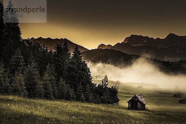 Kleine Hütte auf Bergwiese am Waldrand  Geroldsee im Hintergrund Karwendelgebirge bei Sonnenaufgang  Kaltenbrunn  Oberbayern  Deutschland  Europa