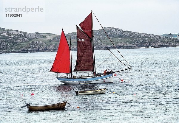 Segelschiff mit roten Segeln  Insel Iona  Innere Hebriden  Schottland  Vereinigtes Königreich  Europa