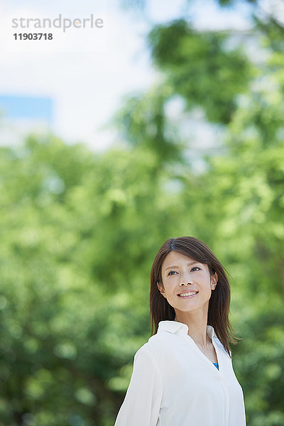 Porträt einer jungen Japanerin und frisches Grün  Tokio  Japan
