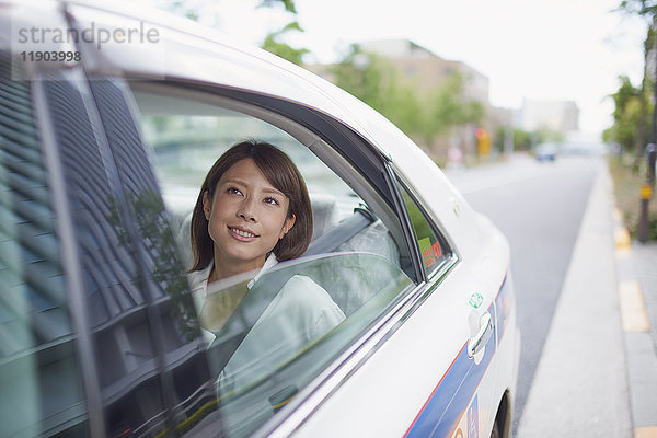 Junge japanische Frau in einem Taxi in der Innenstadt von Tokio  Japan
