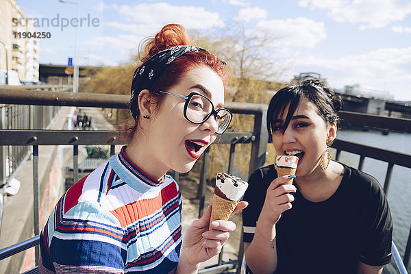 Porträt von Hipster-Freundinnen beim Eis essen in der Stadt