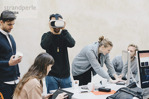 Männlicher Programmierer mit VR-Brille während der Arbeit im Büro