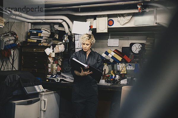 Mechanikerinnen lesen Dokument in der Kfz-Werkstatt
