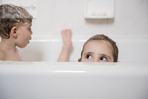 Kaukasisches Mädchen  das aus der Badewanne guckt