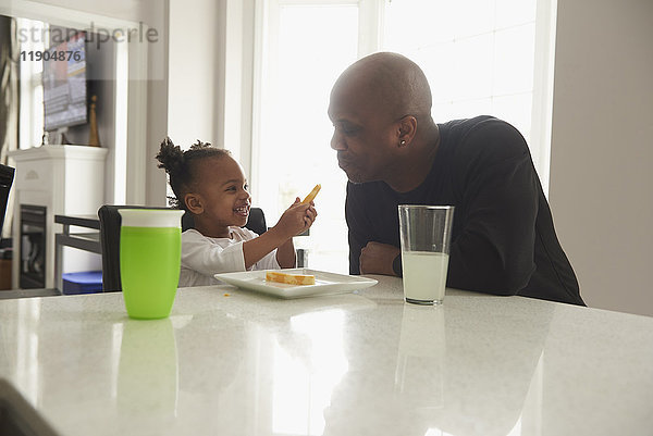 Schwarze Tochter bietet ihrem Vater Essen an