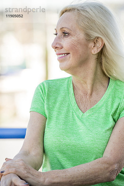 Wind weht Haare der lächelnden kaukasischen Frau