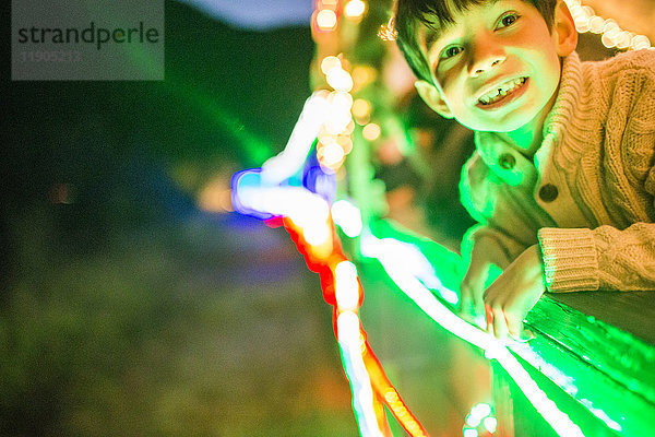 Neonlicht leuchtet auf dem Gesicht eines Mixed Race Jungen