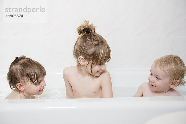 Lächelnder kaukasischer Junge und Mädchen in der Badewanne