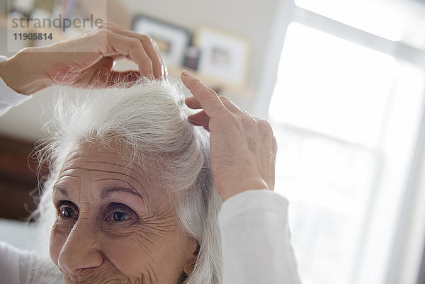 Ältere Frau arrangiert Haare