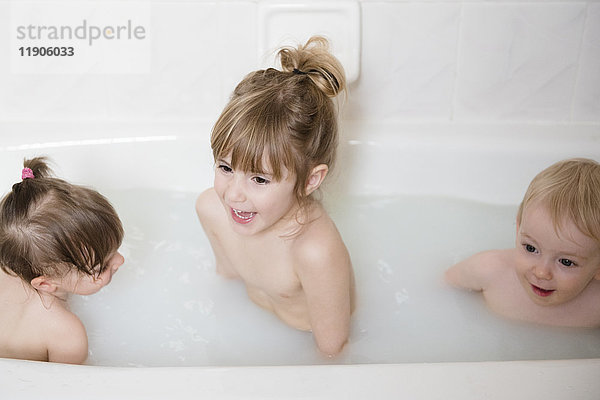Lächelnder kaukasischer Junge und Mädchen in der Badewanne