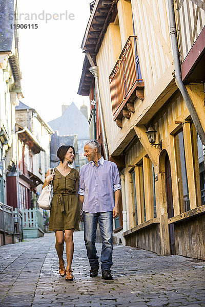 Kaukasisches Paar hält sich an den Händen und geht in der Stadt spazieren