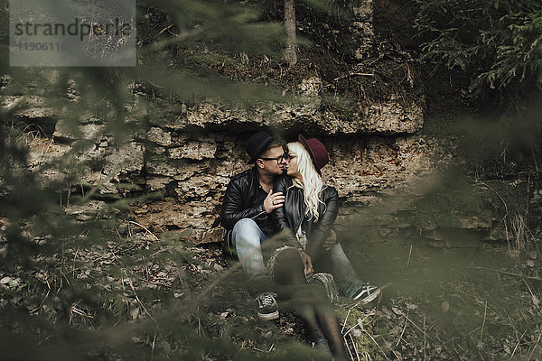 Zärtliches Paar aus dem Nahen Osten küsst sich in der Nähe von Felsen