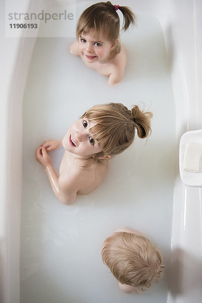 Kaukasischer Junge und Mädchen schauen in der Badewanne auf