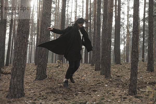 Kaukasische Frau tanzt im Wald