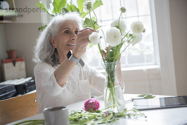 Ältere Frau arrangiert Blumen