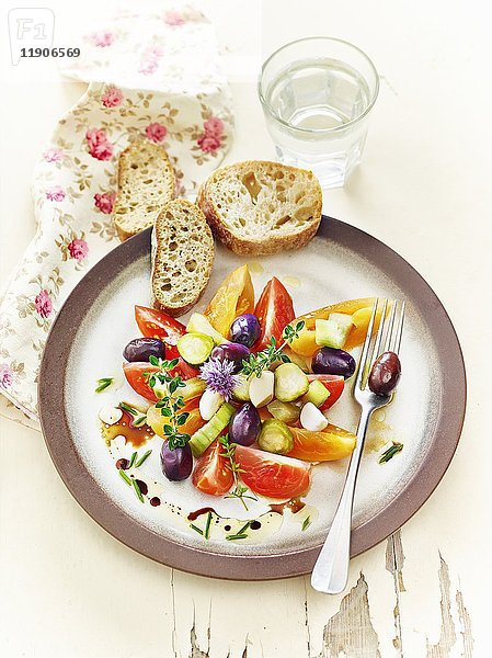 Lakto-fermentierte Tomaten  Gurken und Oliven  serviert mit Kräutern und Knoblauchbrot