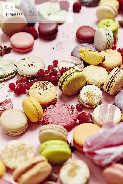 Stilleben mit verschiedenen Sorten französischer Macarons auf einem rosa Hintergrund