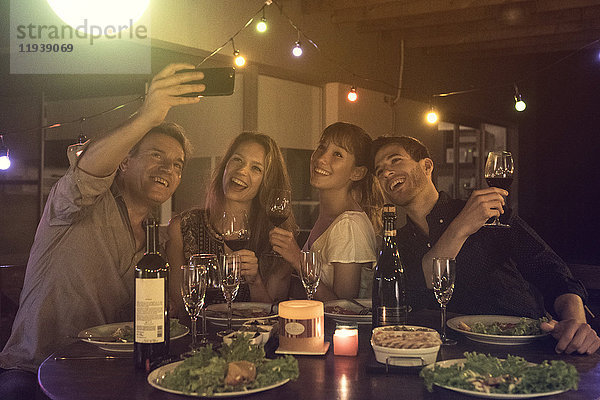 Freunde posieren für Gruppen-Selfie auf der Dinnerparty